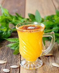 Healthy pumpkin fruit smoothie with seeds and mint leaves on table