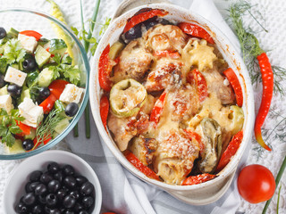 Traditional tasty rustic stew of chicken and vegetables  with Greek salad and black olives