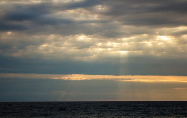 The rays of the sun make their way through the clouds, the seascape