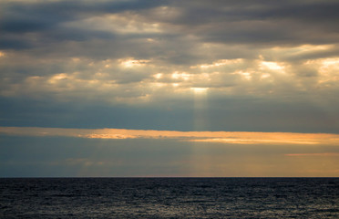 The rays of the sun make their way through the clouds, the seascape