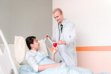 Fototapeta premium Medical at the hospital checking paperwork and patient's medical records, healthcare and teamwork concept.Concept doctor listening to patient's heart in hospital bed.
