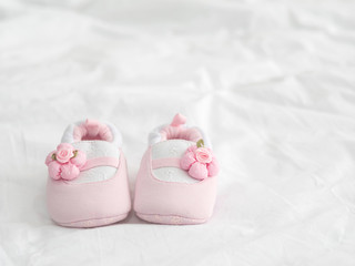 Fototapeta na wymiar A pair of pink baby shoes on blanket with copy space.
