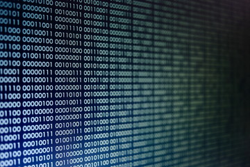 Fototapeta premium blocks of binary data. Blockchain concept. blue background with computer digital binary code bit number one and zero text. selective focus on the far end of the computer display out of focus in front.