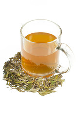 tea in glass cup and dried leaves