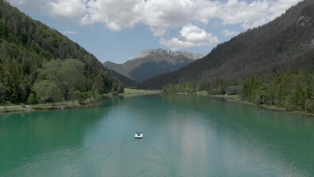 Beautiful Austrian Summer Day // Turquoise lake with paddleboat and mountains in the background // 4K Aerial Cinematography