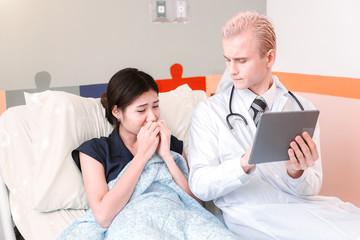 Young male doctor provides treatment counseling to patients in hospital.