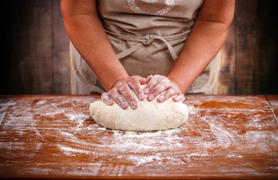 Female hands kneading dough