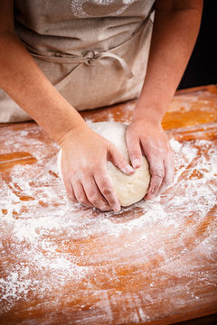 Female hands making bread dough