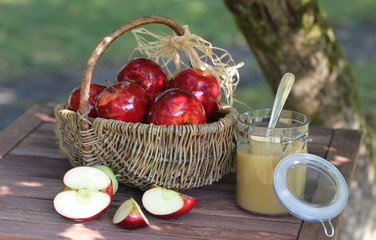 Korb mit roten Äpfeln, Apfelstücken und Apfelmus