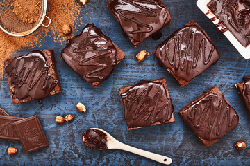homemade chocolate brownies on dark blue background, top view