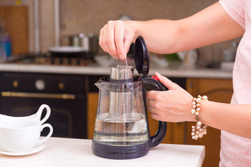 Woman making tea in glass tea pot