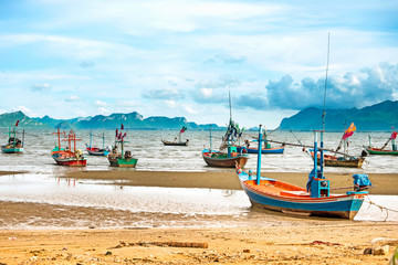 Fishing boat on the beach with blue sky and sea.