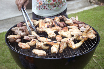 Grilling chicken wings on barbecue grill