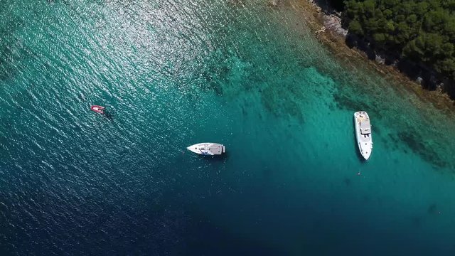 Yachts in amazing clear sea, taken from top in 4k by drone