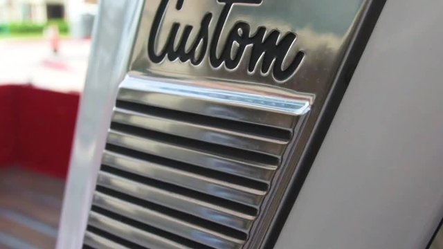 Passenger-side close up, slow-motion pan of a classic C10 pickup Custom logo and B-Pillar trim work from a Florida car show.