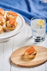 tartlets with mascarpone and red fish on a wooden table