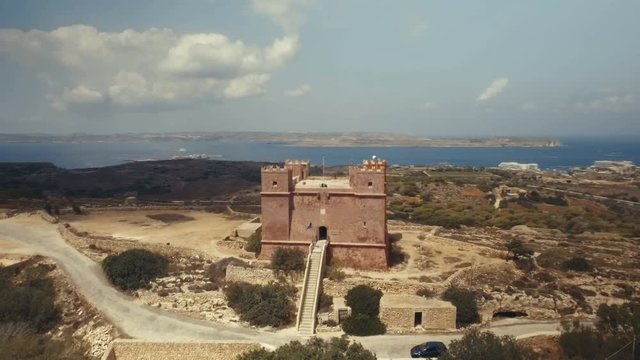 Low Aerial shot rotating around St Agatha's Red Tower in Mellieha Malta