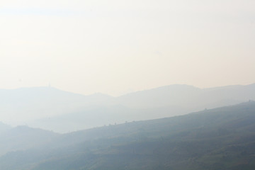 Fototapeta premium Beautiful landscape and fog on the mountain and blue sky. Sunrise shining to the mist in forest of Thailand.