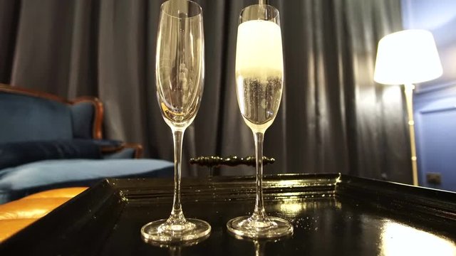 Pour to fill two champaign glasses celebrate in interior room
