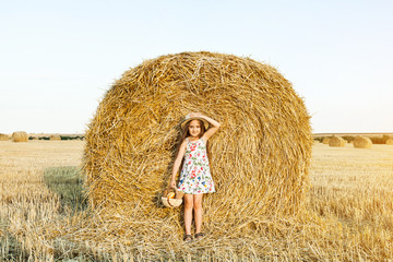 Naklejka na ściany i meble Happy girl on field of wheat with bread