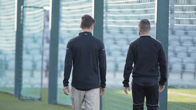 Two soccer team mates walking to practice in slow motion