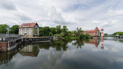 Fototapeta premium Wehr mit Leuchtturm und Alter Mühle im Hintergrund in der Kreisstadt Rathenow im Havelland