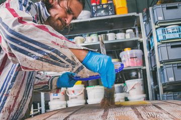 Artist using paint brush for making artificial wood texture.