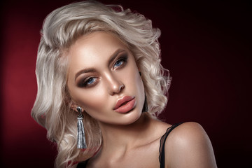 Glamorous Beauty portrait of a superb blonde girl. Bright makeup, chubby lips. Chic decoration.