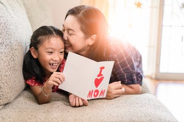 Daughter give mother day greeting card to mom