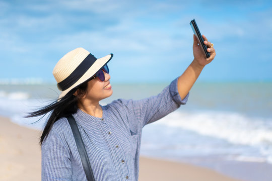 Traveller woman taking selfie photo on the beach