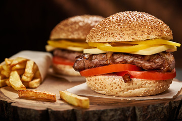 fresh tasty cheeseburger and french fries on wooden table
