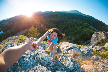 A girl is climbing a stone.
