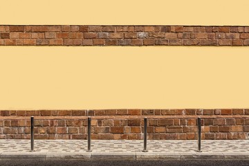 The yellow wall of the house, the sidewalk on the street, columns.