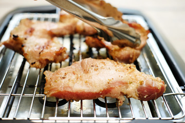 Delicious pieces of meat with spices on the electric grill.