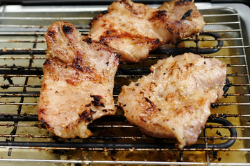 Delicious pieces of meat with spices on the electric grill.