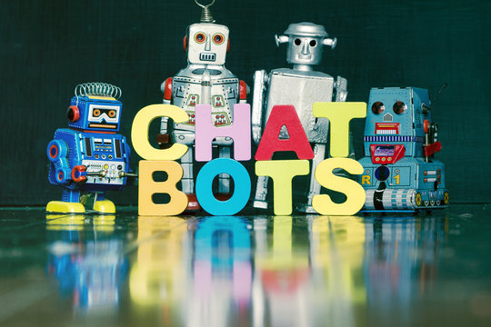 the word  CHAT BOTS with rtro robots on a wooden floor 1