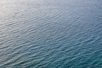 Aerial view of the sea surface. High resolution bird's eye image showing sea waves and currents from above.