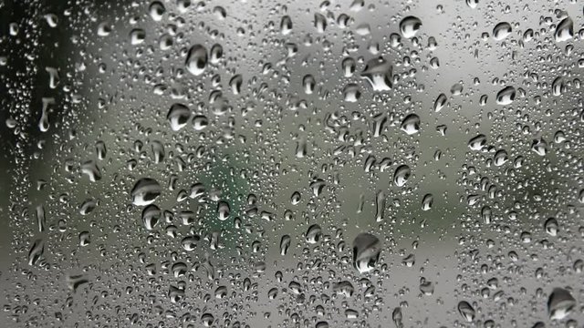 Raindrops drip on the window