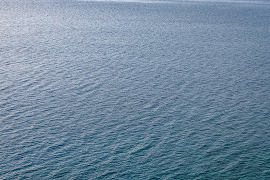 Aerial view of the sea surface. High resolution bird's eye image showing sea waves and currents from above.