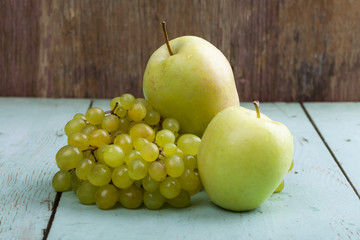 apples and grapes on wooden background