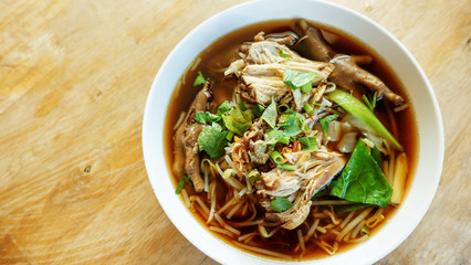 Thai chicken noodle on a wooden table.