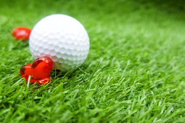 Golf ball with heart shape for golfer lover are on green grass