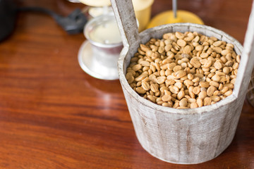 Brown coffee beans in a wooden bucket
