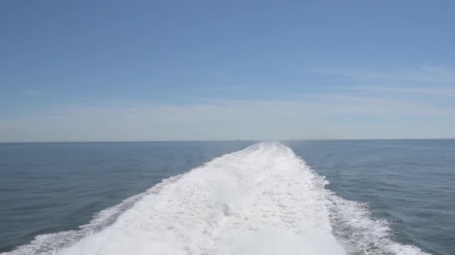 wake or backwash of large high speed vessel on open sea on clear sunny day