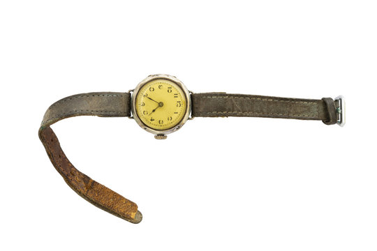 Closeup of a retro style yellow colored wristwatch with worn leather straps isolated on white background.