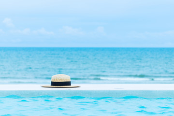 Obraz na płótnie Canvas Bamboo hat accessories on tropical beach and blue sky with copy space