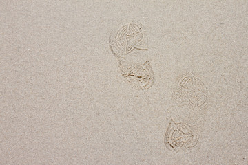 Trace the shoes on the sandy beach.