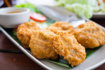 Thai Shrimps pancakes in white dish on wooden table background.