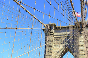 Obraz premium Zbliżenie na Brooklyn Bridge i American Flag nad East River, Nowy Jork, USA