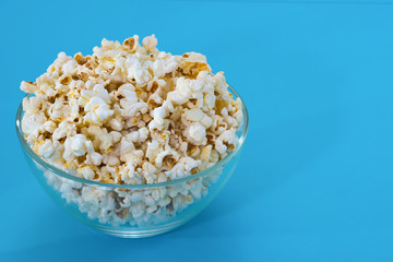 Popcorn in a bowl, on a blue background. closeup